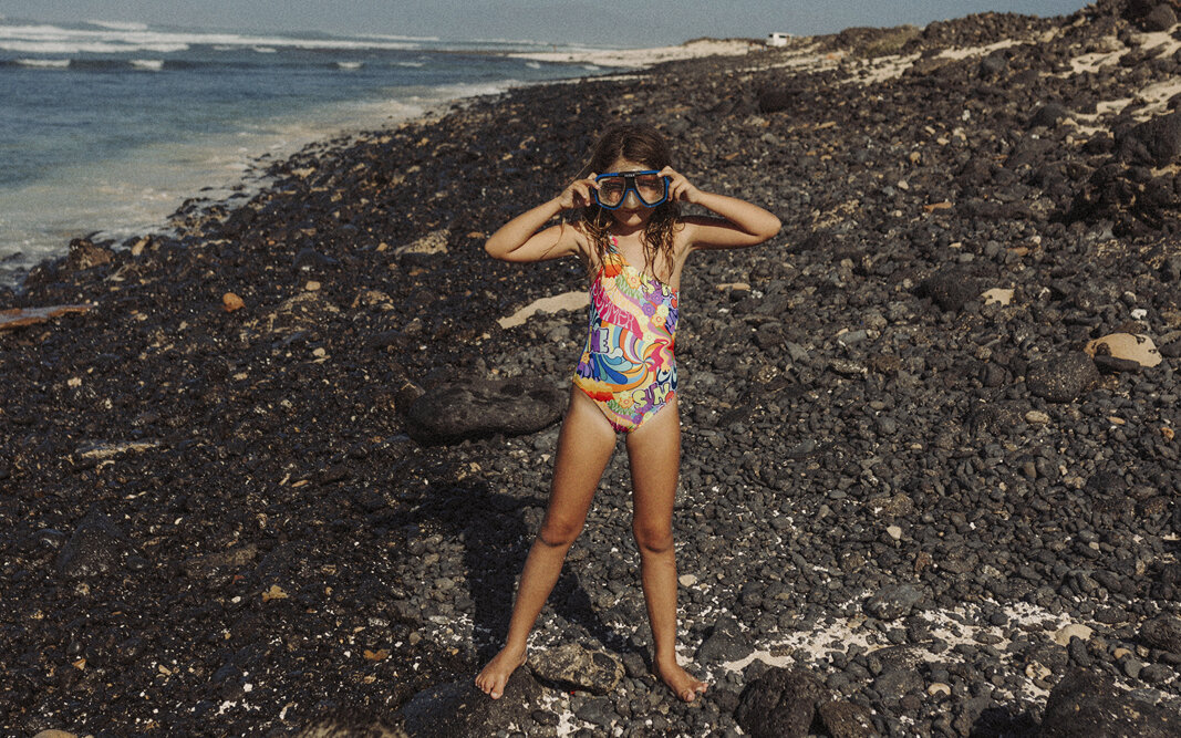 Niña en las rocas de la playa